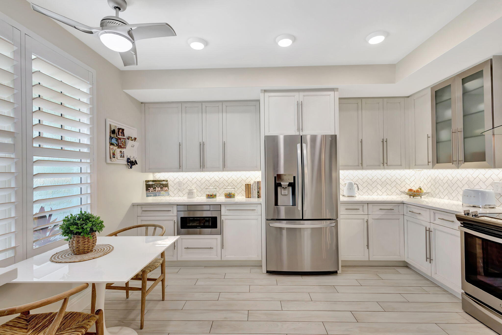 204 Mainsail Circle Jupiter, FL 33477 - Photo 10 of 60 a kitchen with stainless steel appliances a stove a refrigerator a sink dishwasher a oven with white cabinets and wooden floor