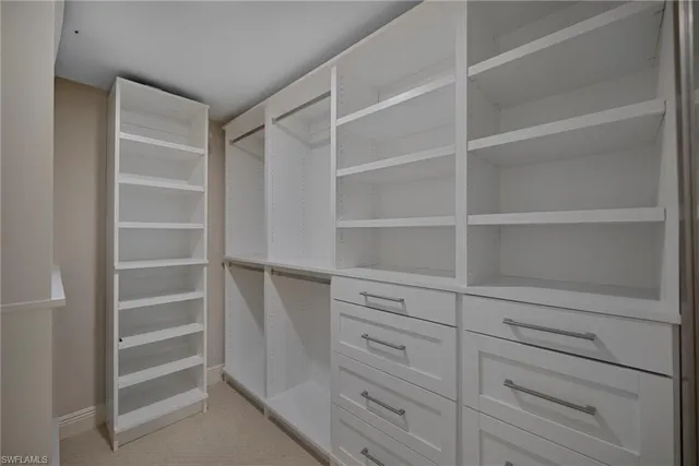 a view of walk in closet with empty racks