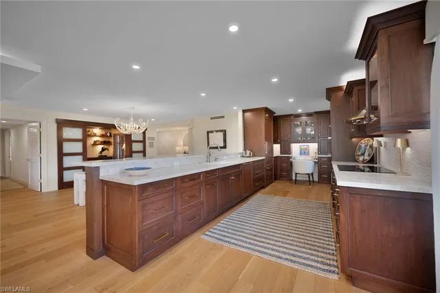 a large kitchen with stainless steel appliances kitchen island granite countertop a large counter top and wooden floors