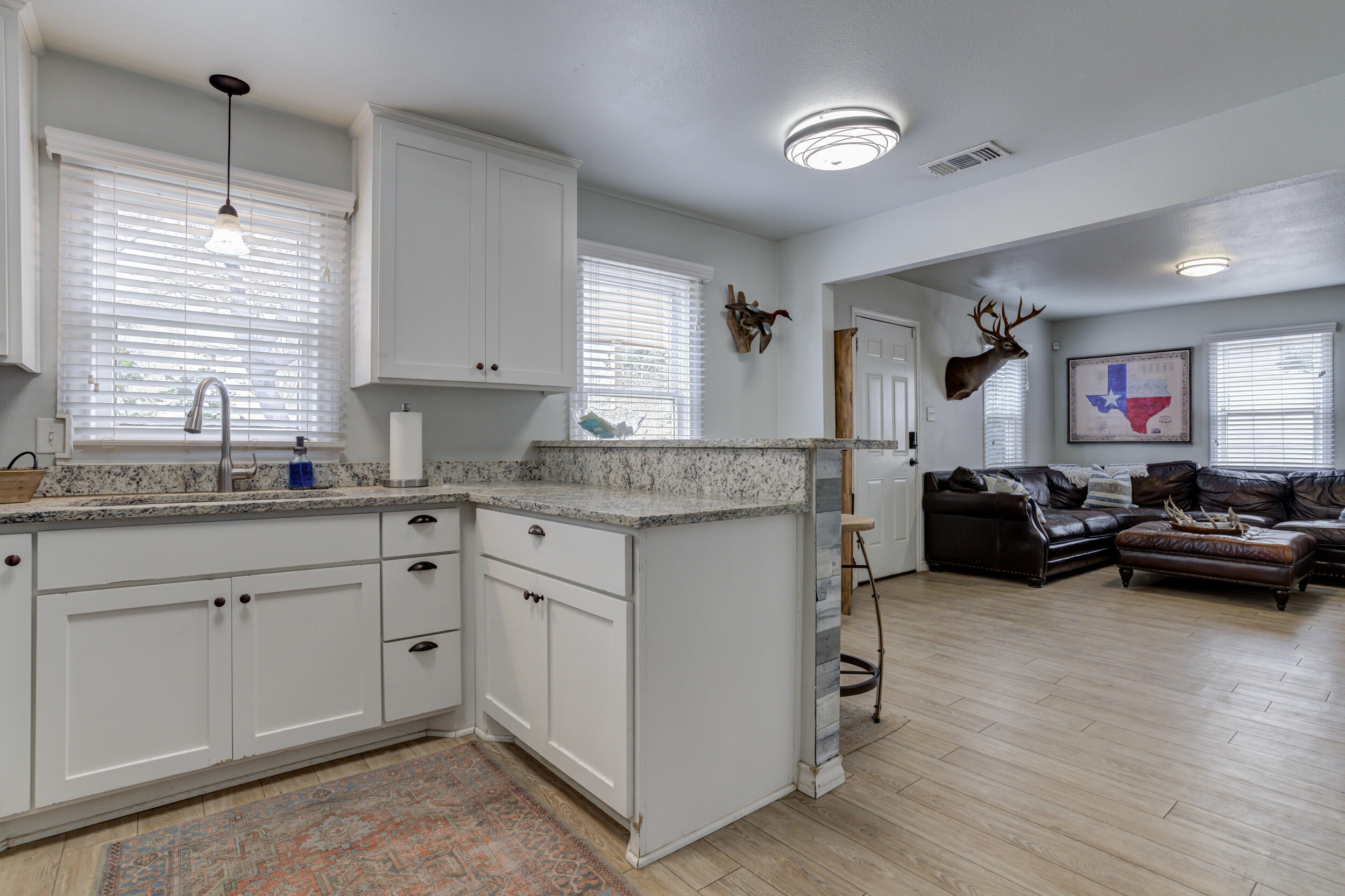 2515 33rd Street Lubbock, TX 79410 - Photo 21 of 41 a kitchen that has a lot of cabinets in it and wooden floors
