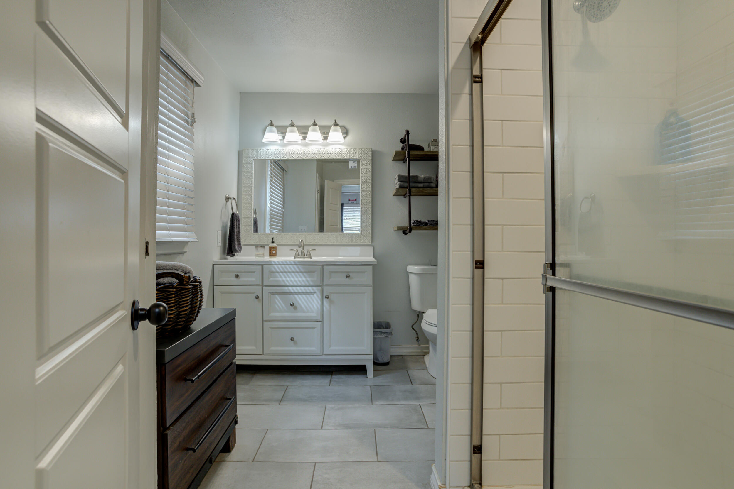 2515 33rd Street Lubbock, TX 79410 - Photo 27 of 41 a bathroom with a double vanity sink a mirror and a shower