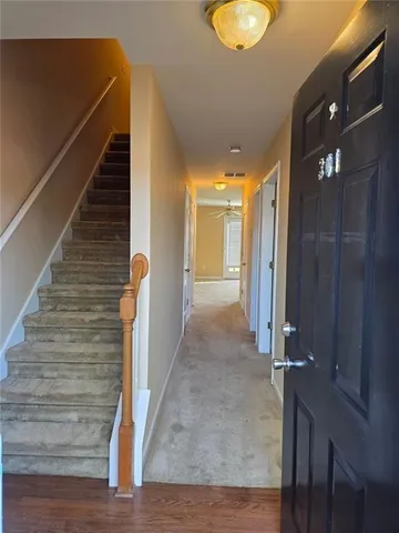a view of a hallway with wooden floor and staircase