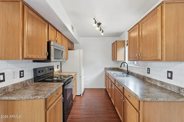 a kitchen with stainless steel appliances granite countertop a sink stove and cabinets