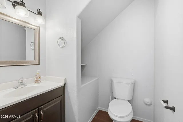 a bathroom with a toilet a sink and mirror