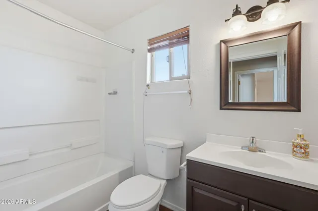 a bathroom with a sink toilet vanity and tub