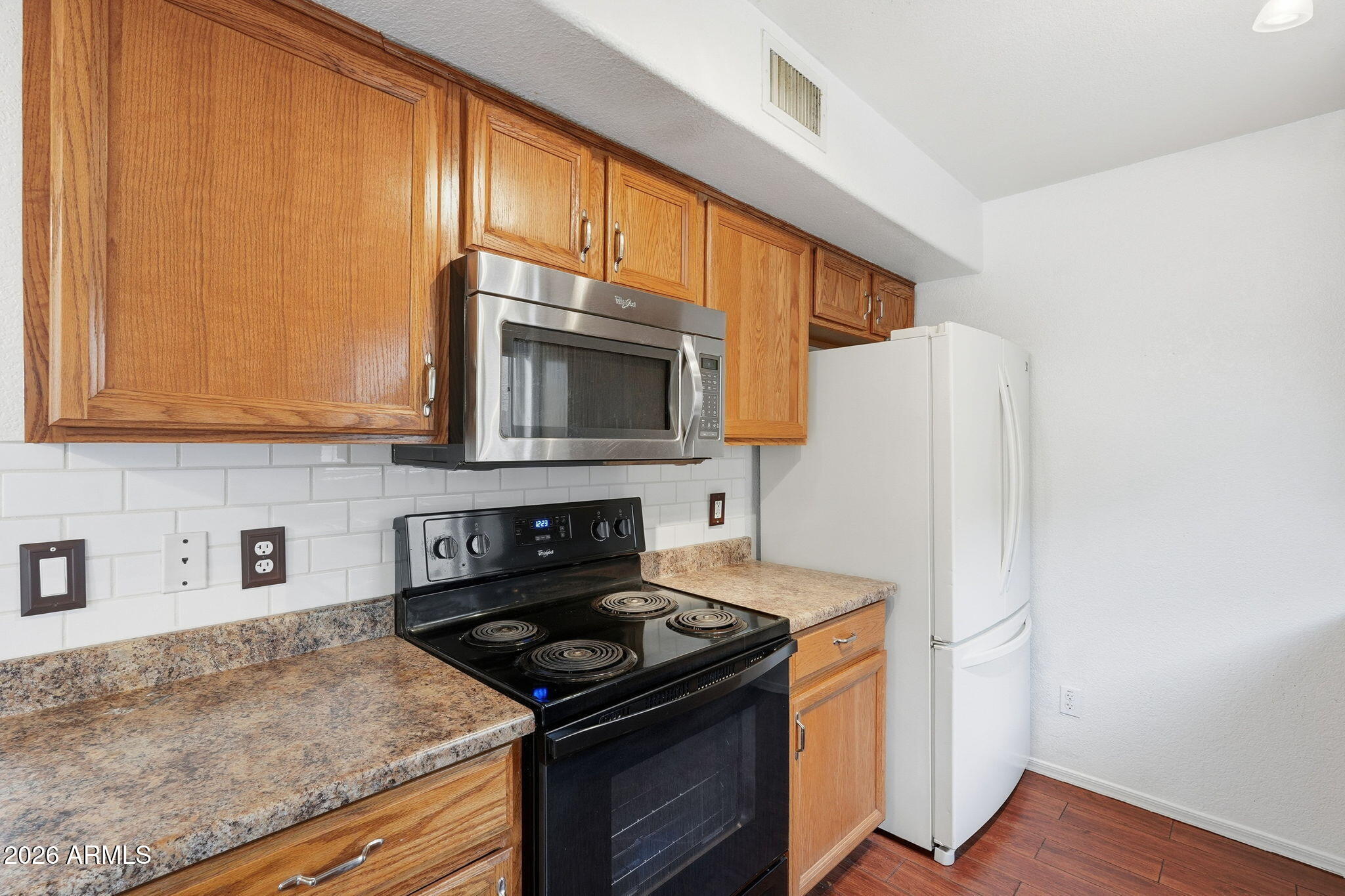 16202 North Desert Sage Street Surprise, AZ 85378 - Photo 7 of 25 a kitchen with stainless steel appliances granite countertop a stove microwave refrigerator and sink