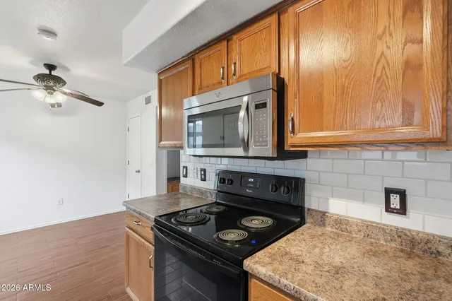 a kitchen with stainless steel appliances granite countertop a stove a sink and a microwave