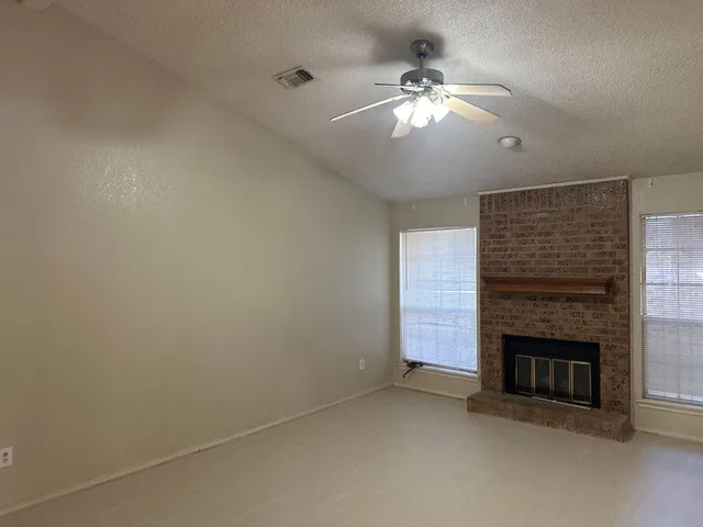 en empty room with fireplace and fan