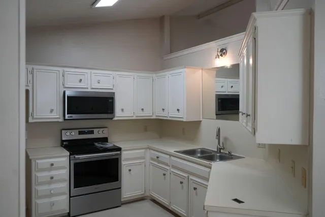 a kitchen with granite countertop a stove and a sink