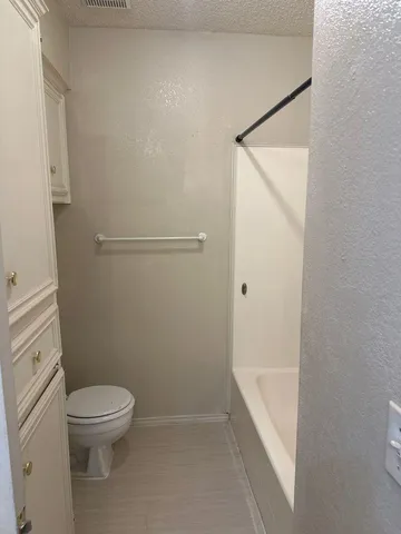 a bathroom with a granite countertop toilet a sink and shower