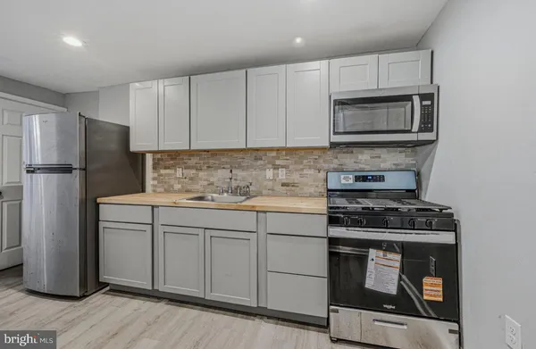 a kitchen with white cabinets sink and stainless steel appliances
