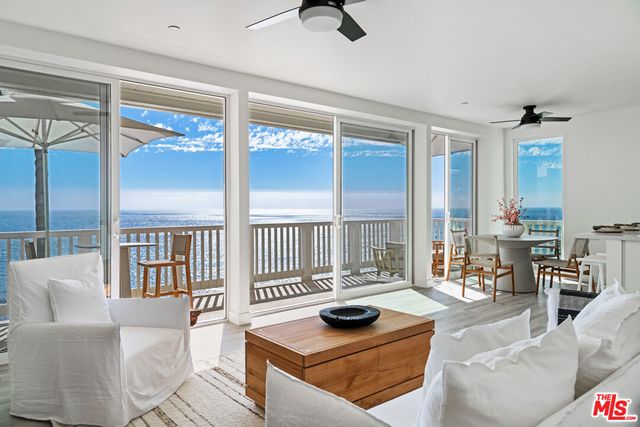 a living room with furniture and floor to ceiling windows