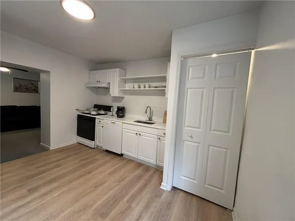 a kitchen with white cabinets and black appliances