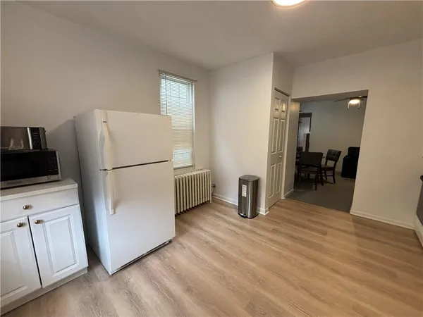 a view of kitchen with furniture wooden floor and electronic appliances