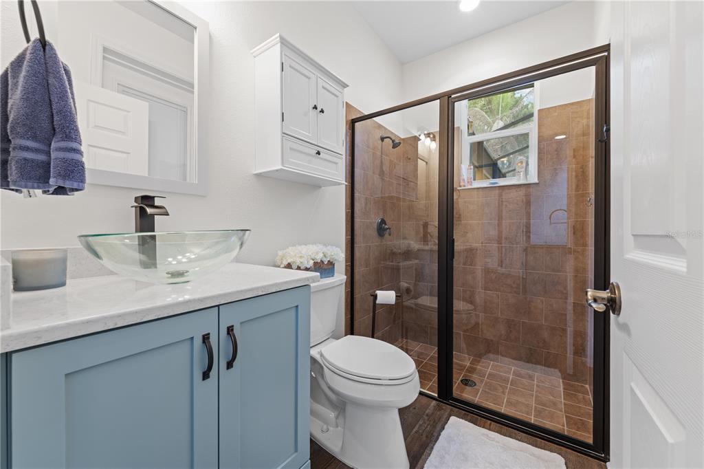 16948 Deer Island Road Tavares, FL 32778 - Photo 26 of 67 a bathroom with a shower sink vanity mirror and toilet