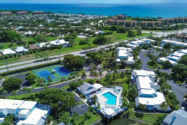 an aerial view of a city with lots of residential buildings and mountain view in back