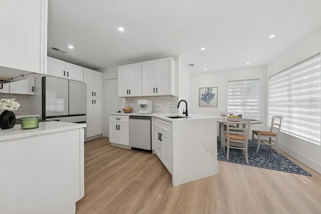 a kitchen with a sink a counter top space stainless steel appliances and cabinets