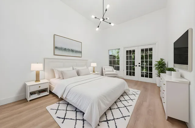 a spacious bedroom with a bed and a flat screen tv