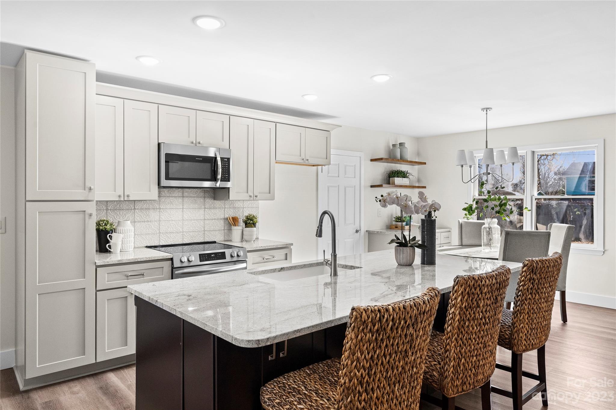 1621 Brook Drive Fort Mill, SC 29708 - Photo 10 of 30 a kitchen with kitchen island granite countertop a table chairs microwave and cabinets