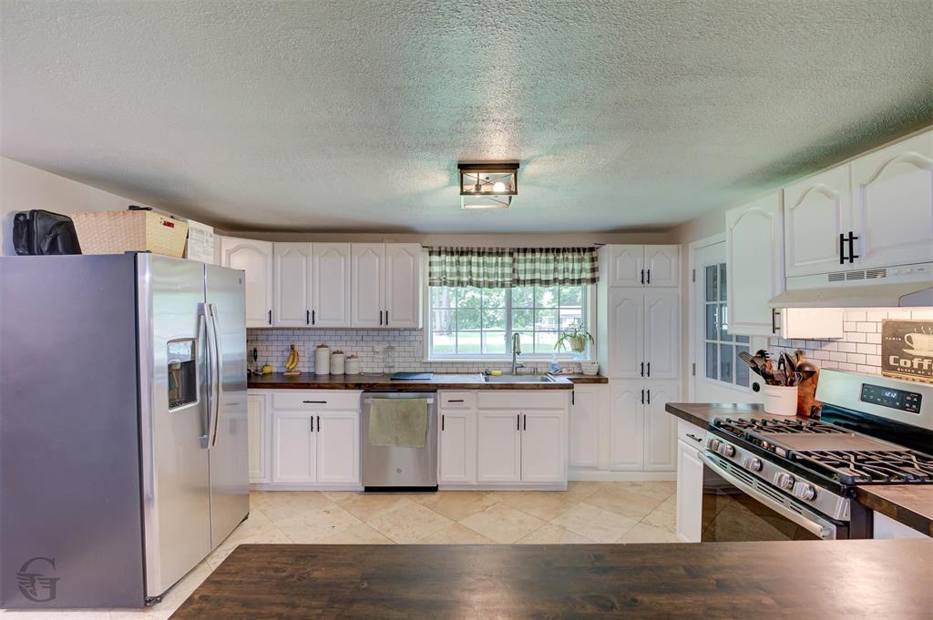 701 Chandler Road Haughton, LA 71037 - Photo 9 of 25 a kitchen with stainless steel appliances a stove a sink a refrigerator cabinets and a window