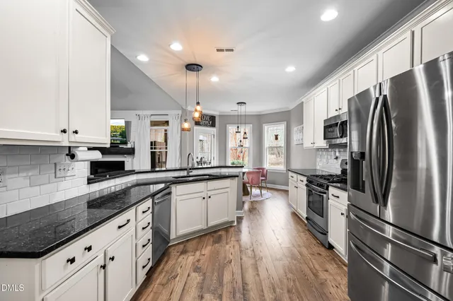 a large kitchen with stainless steel appliances sink a stove and refrigerator