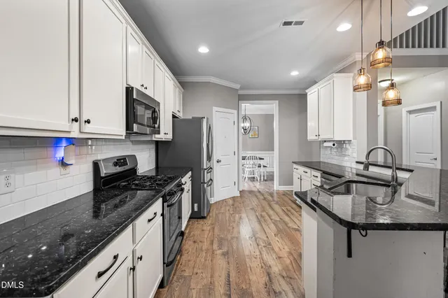 a kitchen with kitchen island granite countertop a sink stainless steel appliances and cabinets