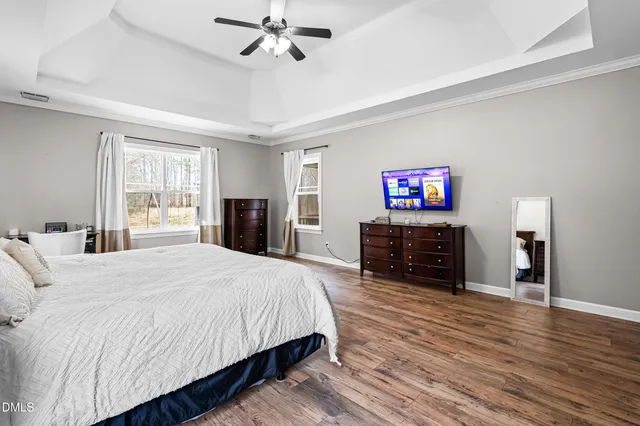 a spacious bedroom with a bed and a flat screen tv