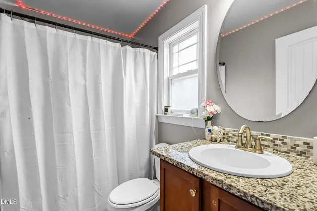 a view of staircase with lots of frames on wall and wooden floor