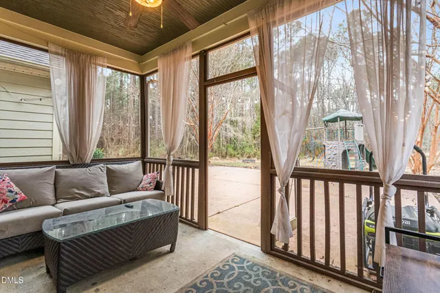 a view of a porch with wooden floor and furniture
