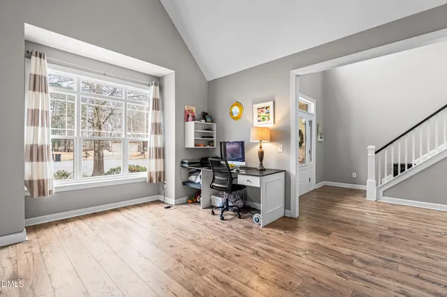 a view of a workspace with wooden floor and a window