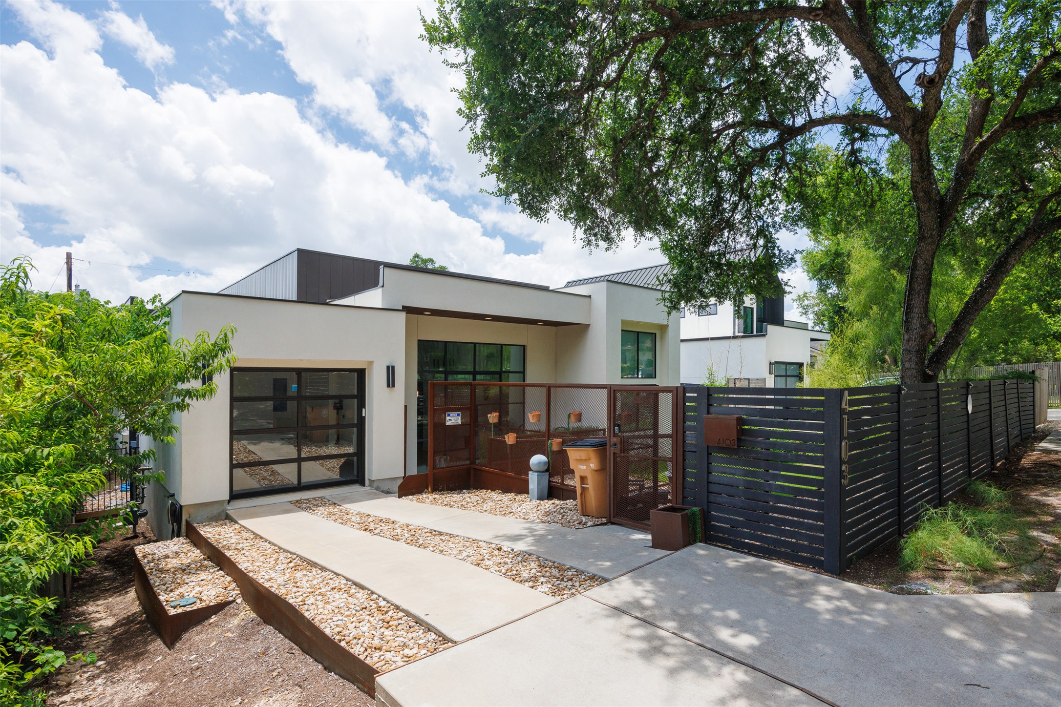 4103 Ridgelea Drive Austin, TX 78731 - Photo 25 of 26 A modern facade with a sleek garage door and concrete driveway defines this inviting residence.