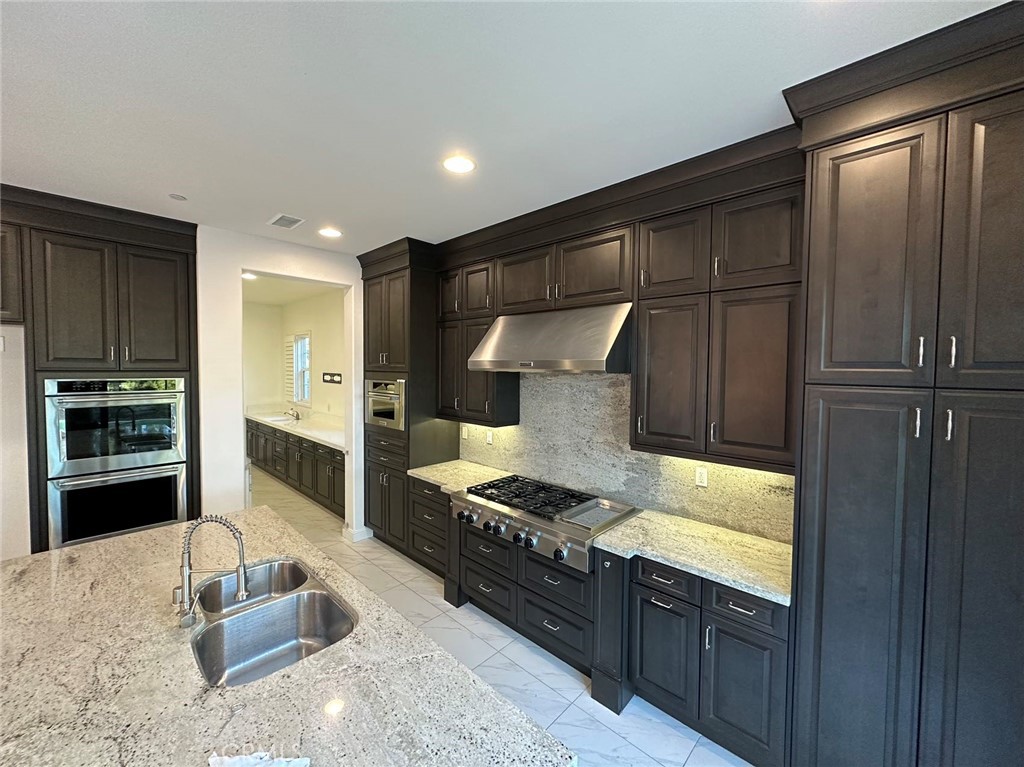 20 Hyacinth Lake Forest, CA 92630 - Photo 8 of 25 a kitchen with granite countertop stainless steel appliances and wooden cabinets