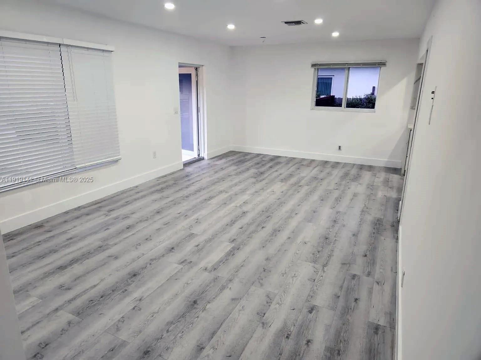 1269 Northeast 145th Street Miami, FL 33161 - Photo 12 of 13 an empty room with wooden floor and windows