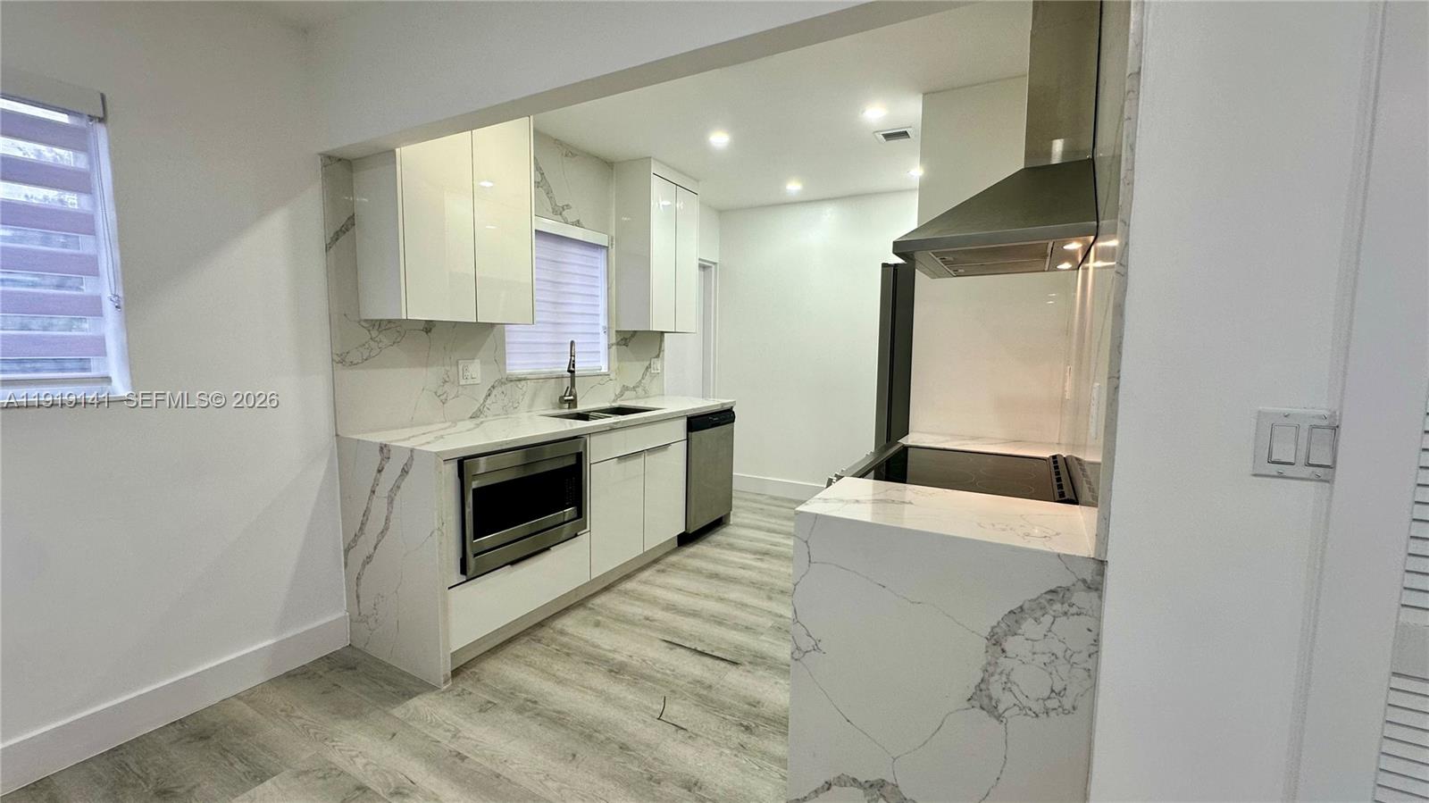 1269 Northeast 145th Street Miami, FL 33161 - Photo 14 of 25 a kitchen with stainless steel appliances a stove a sink and a refrigerator