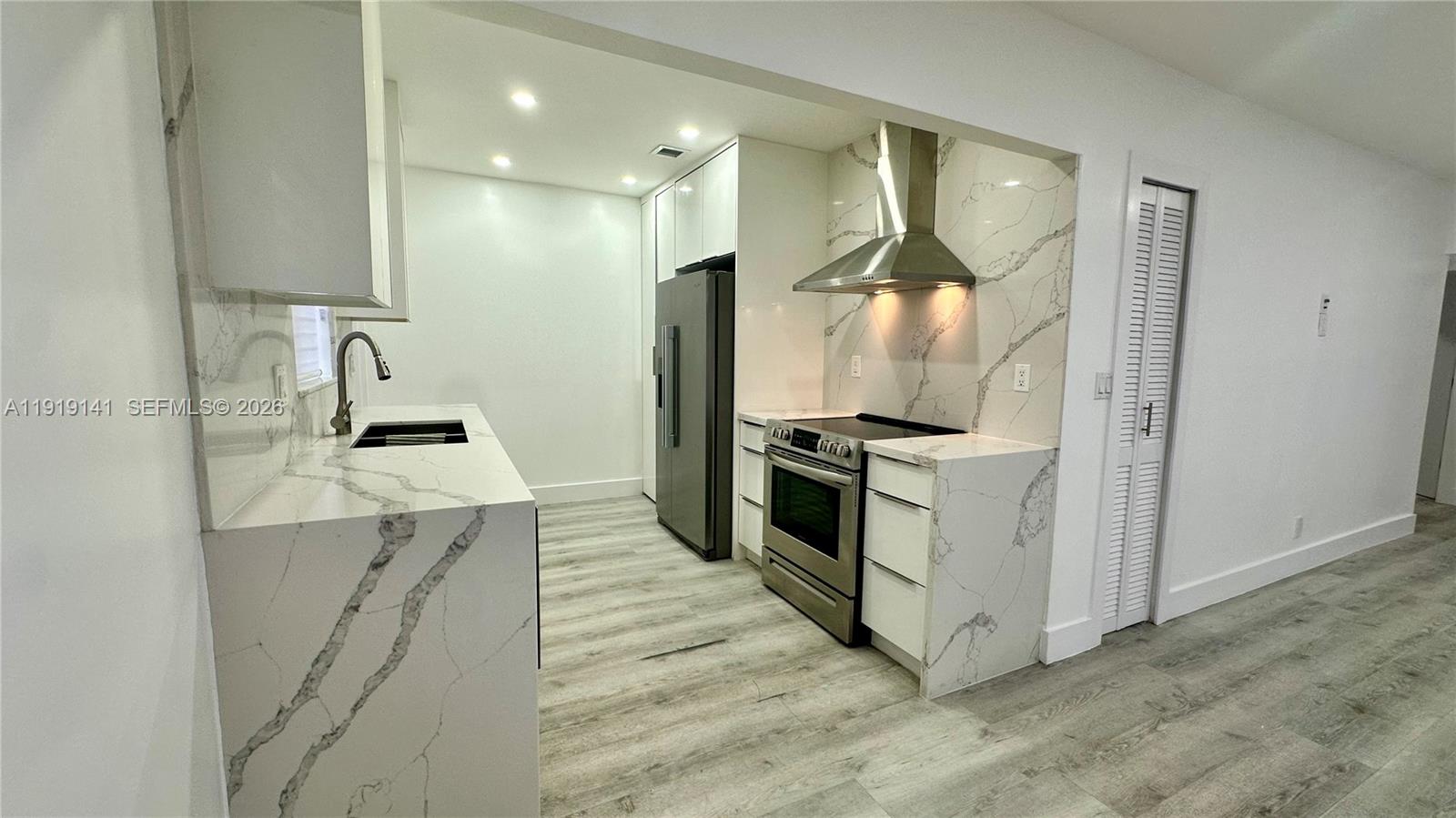 1269 Northeast 145th Street Miami, FL 33161 - Photo 15 of 25 a kitchen with granite countertop a sink and stainless steel appliances
