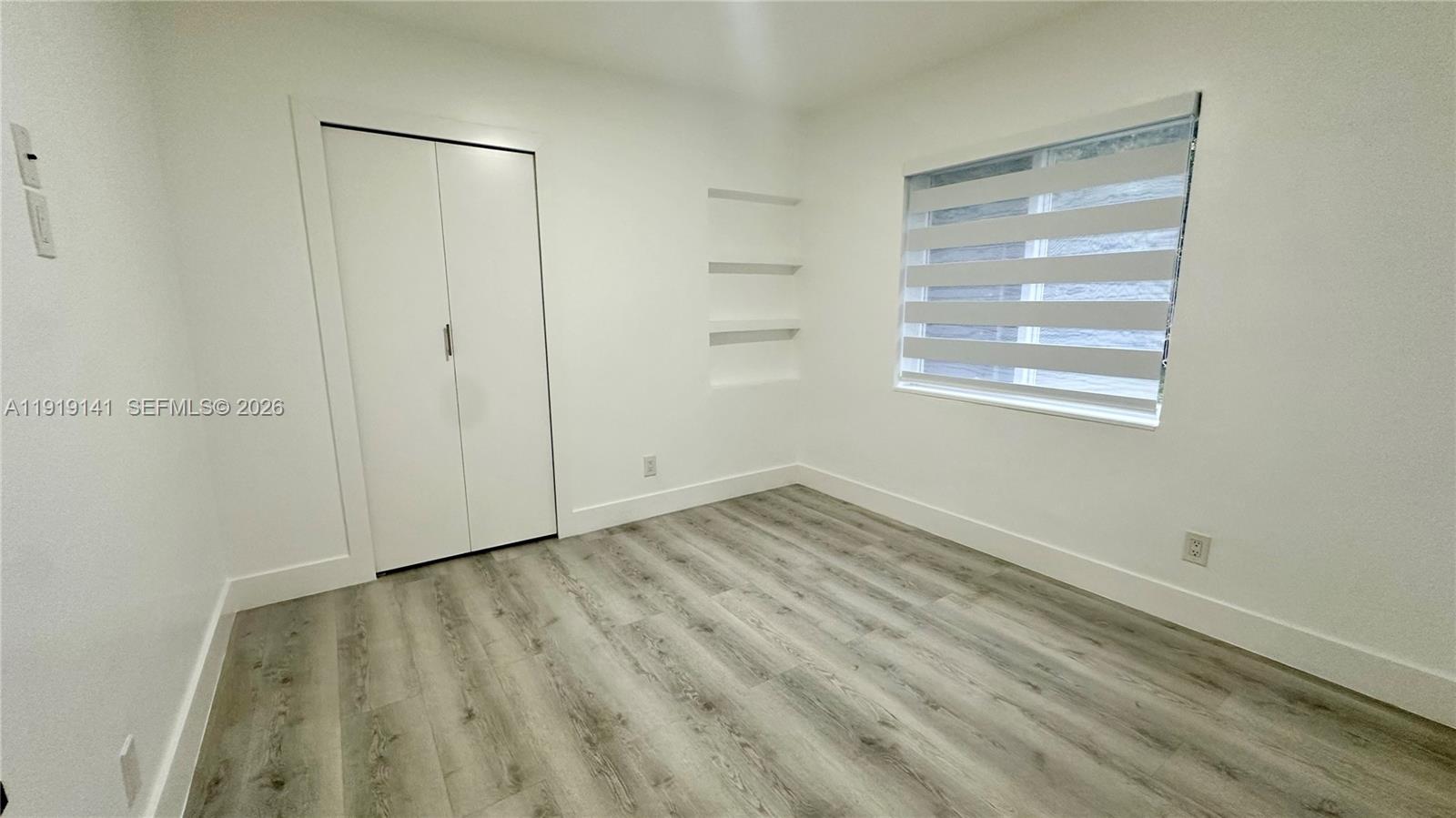 1269 Northeast 145th Street Miami, FL 33161 - Photo 22 of 25 a view of an empty room with wooden floor and a window