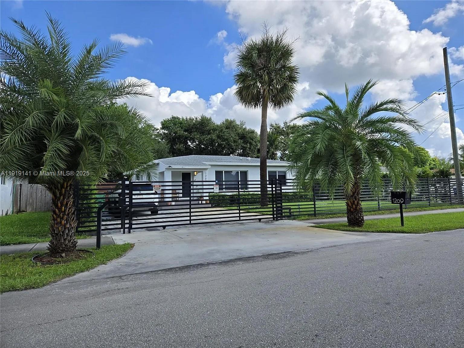 1269 Northeast 145th Street Miami, FL 33161 - Photo 4 of 13 a house with palm trees in front of it
