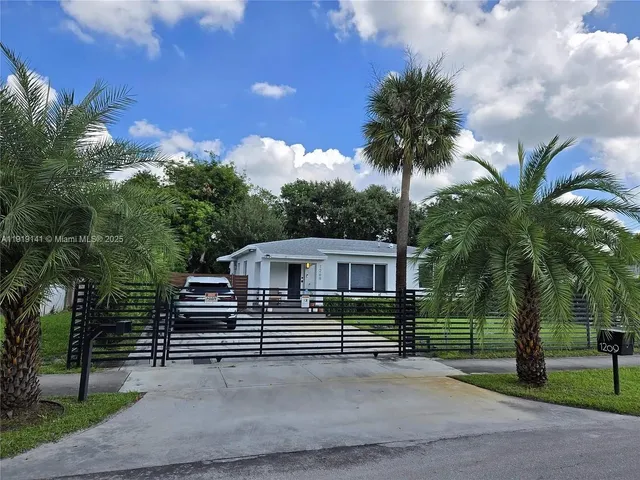 a view of a house with a yard and potted plants