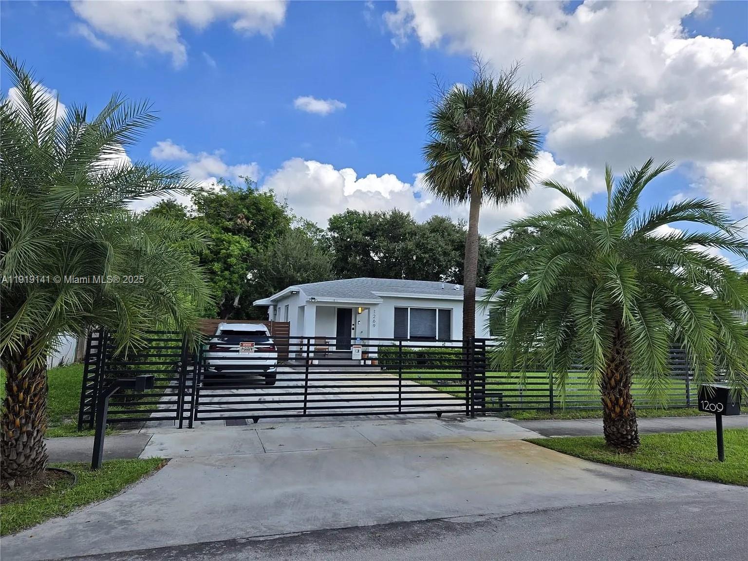 1269 Northeast 145th Street Miami, FL 33161 - Photo 5 of 13 a view of a house with a yard and potted plants