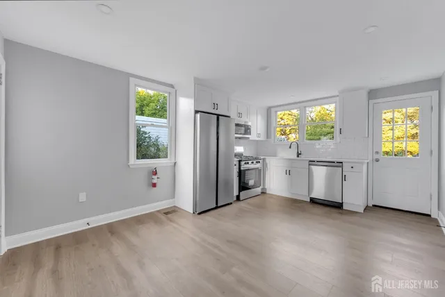 a kitchen with stainless steel appliances a refrigerator and a stove top oven
