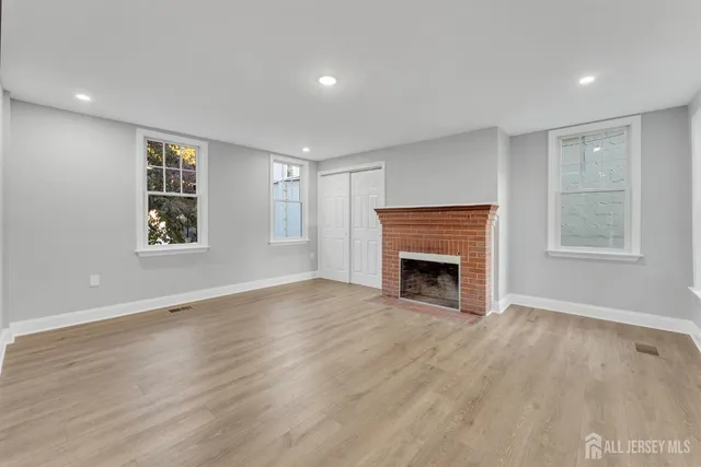 a view of an empty room with a window and fireplace