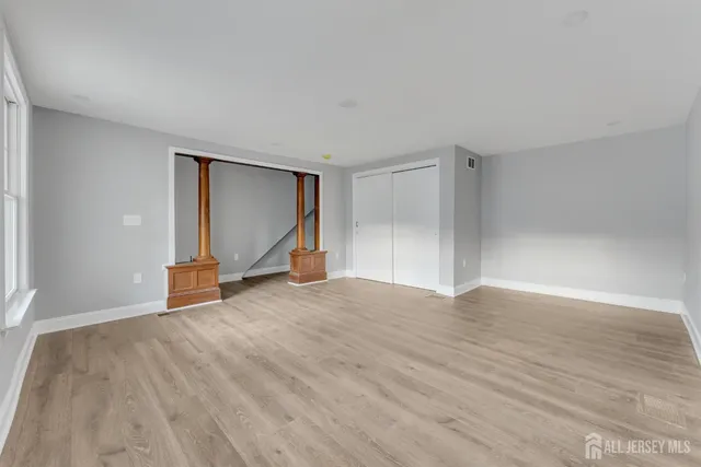 a view of empty room with wooden floor