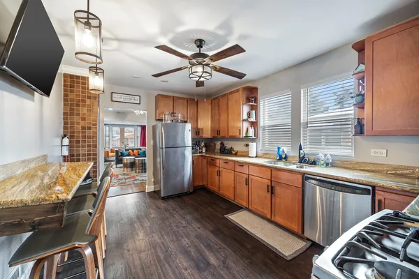 a kitchen with stainless steel appliances granite countertop a sink and wooden floors