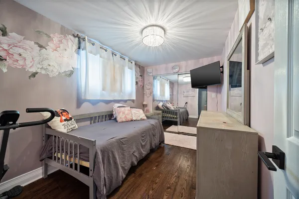 a bedroom with furniture a flat screen tv and a window