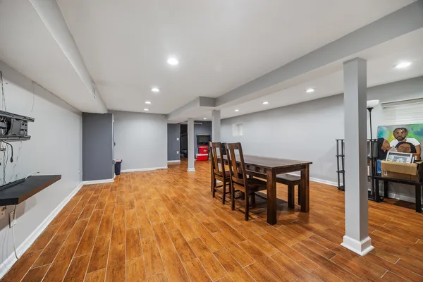 a living room with furniture and kitchen view with wooden floor