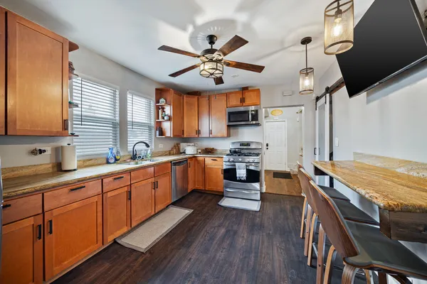 a large kitchen with cabinets wooden floor and stainless steel appliances