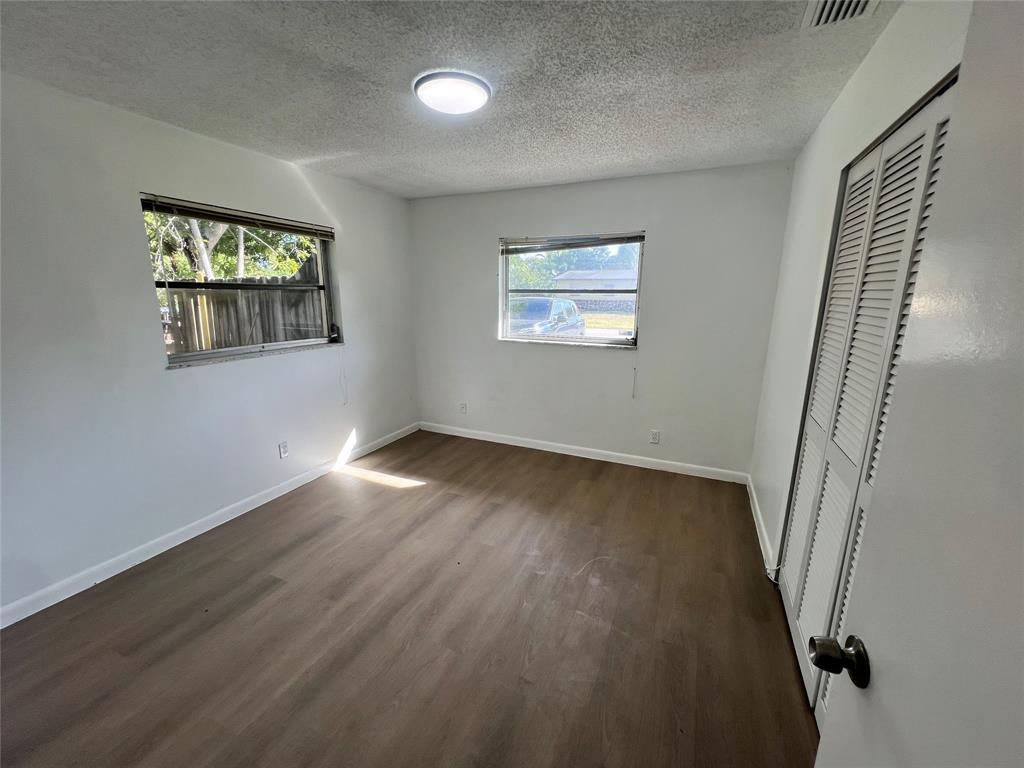 3321 Grove Road Boynton Beach, FL 33435 - Photo 5 of 9 an empty room with wooden floor and windows