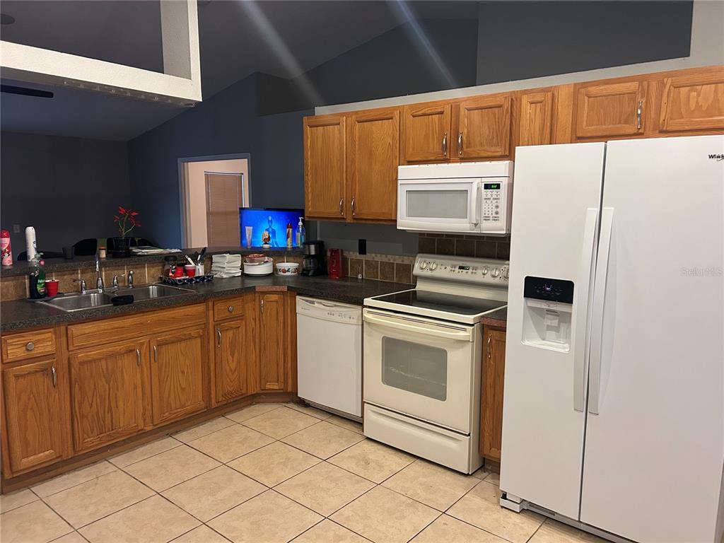 706 Hawk Lane Kissimmee, FL 34759 - Photo 2 of 9 a kitchen with stainless steel appliances a refrigerator sink and microwave