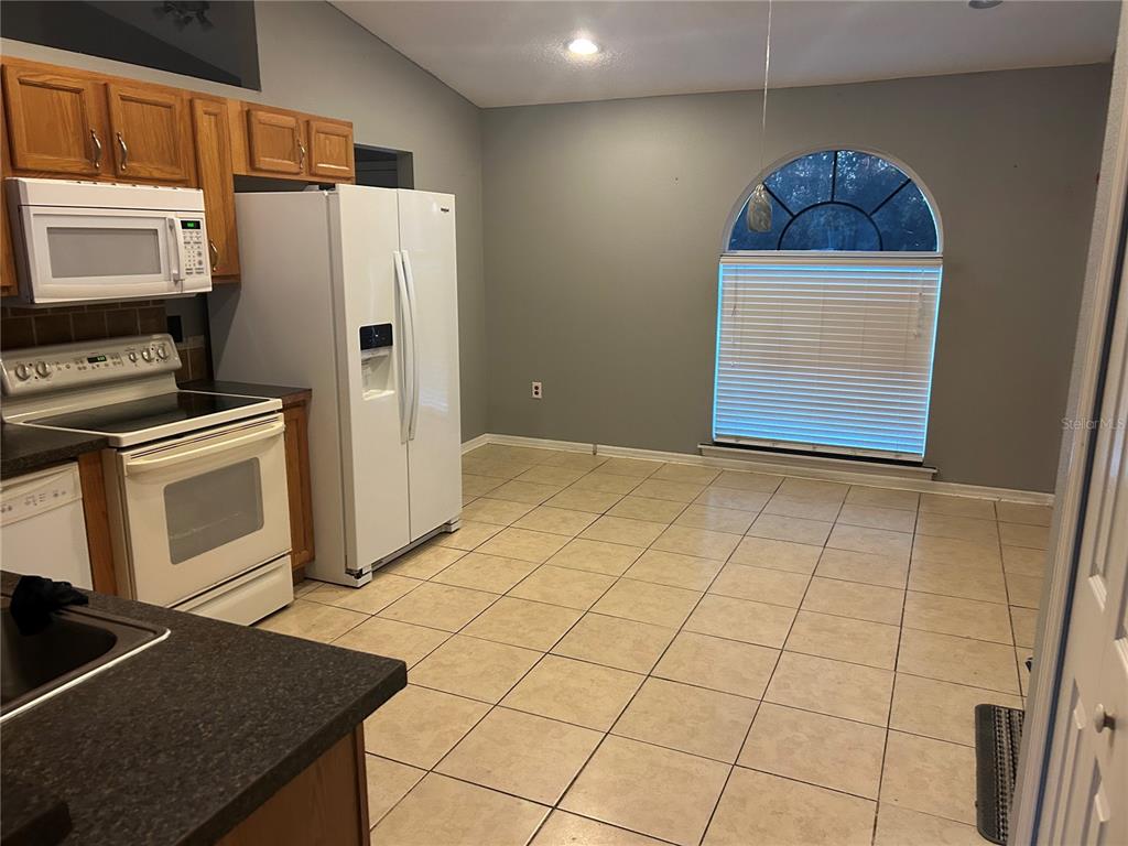 706 Hawk Lane Kissimmee, FL 34759 - Photo 3 of 9 a kitchen with stainless steel appliances granite countertop a stove a refrigerator and a microwave