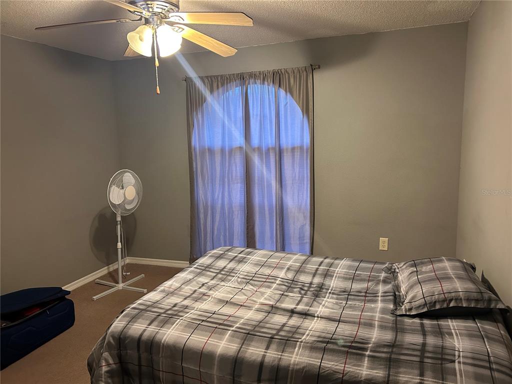 706 Hawk Lane Kissimmee, FL 34759 - Photo 8 of 9 a bedroom with a bed and a chandelier